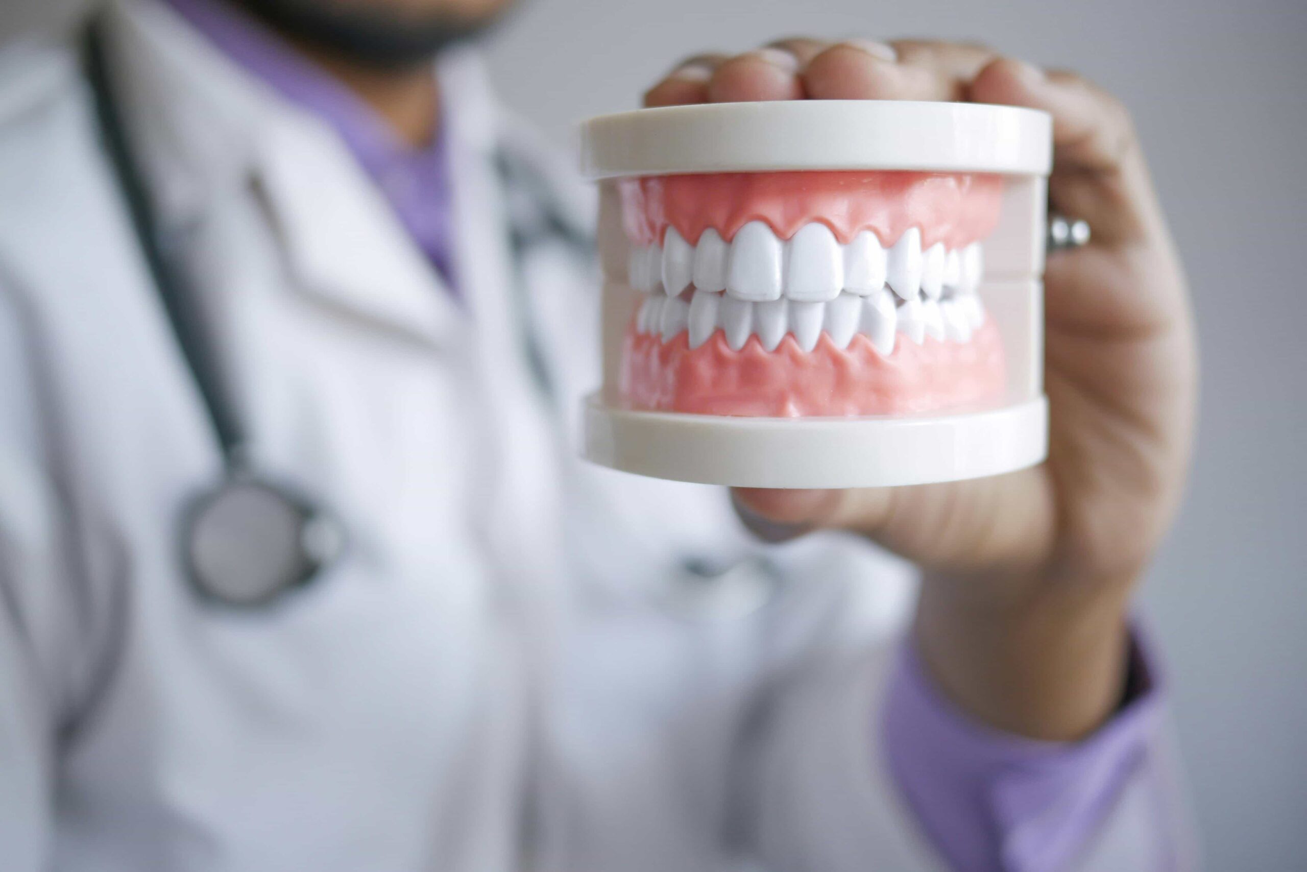 orthodontist holding invisalign on teeth